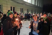 Wolontariusze przed szkoła palący światełko