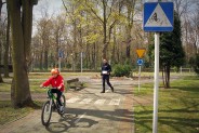 Policjant ocenia przejazd chłopca na rowerze przez tzw. rowerowe miasteczko.