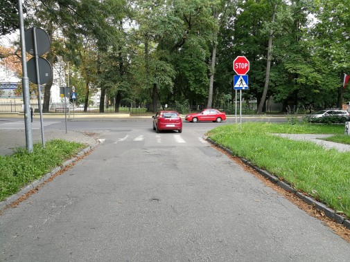 Skrzyżowanie ulicy W. Sikorskiego z ul. Oświęcimską. Na skrzyżowaniu stoi czerwony samochód.