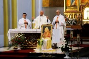 Przy ołtarzu stoją księża celebrujący uroczystą mszę świętą