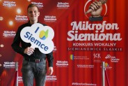 Michał Stuchły na tle czerwonej ścianki reklamowej konkursu