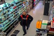 Poszukiwany mężczyzna idący wzdłuż sklepowych półek