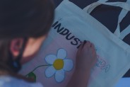 Dziewczynka pisząca na torbie wyraz "industriada".