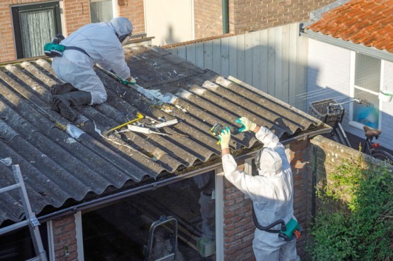 Robotnicy podczas pracy na pokryrtym azbestem dachu