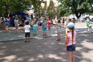 Dzieci ustawione na Rynku Miejskim z zachowaniem dystansu podczas zabaw animacyjnych z balonami