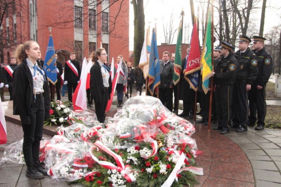 Poczty sztandarowe otaczają pokryty kwiatami pomnik Nieznanego Żołnierza.