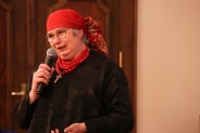 Wanda Bujoczek z mikrofonem ubrana w śląski strój z czerwoną chustką na głowie