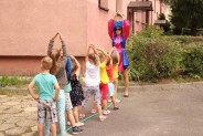 Dzieci stoją w jednym rzędzie przed prowadzącą zabawę