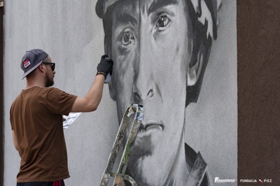 Człowiek malujący grafitti z twarzą ludzką