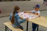 Chłopiec i dziewczynka siedzą przy stole ze swoim malunkiem
