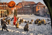 Żołnierze Armii Czerwonej na tle budynku szkoły w zimowej szacie z boku publicznośc przyglądajaca…