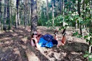 Dziewczyna z plecakiem odpoczywa w lesie