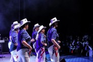 Na scenie amfiteatru, podczas Pikniku Country, zespół tańca liniowego w białych kapeluszach…