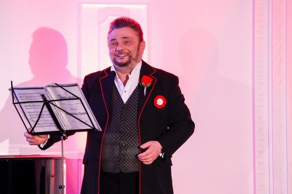 Na zdjęciu Juliusz Ursyn Niemcewicz ubrany w czarną marynark z biało-czerwonym kotylionem i różą…