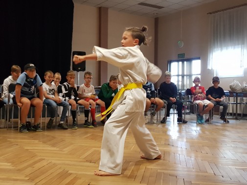 Chłopiec ubrany w kimono pokazuje umiejętności karate