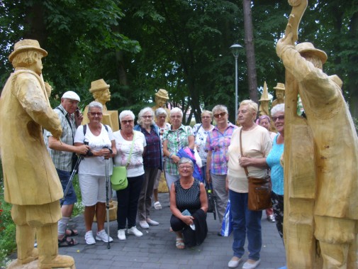 CZłonkowie ŚSKON przy drewnianych rzeźbach