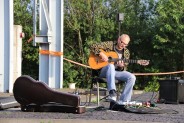 Gitarzysta Adam Bul, siedząc pod szybem Krystyn w Parku Tradycji gra koncert