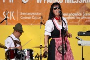 Wokalistka zespołu Tyrolia Band śpiewa na scenie do mikrofonu. Ma na sobie ludowy strój bawarski.…