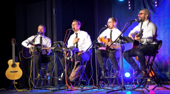 Na scenie SCK-Bytków zespół Albo i Nie. Muzycy ubrani w białe koszule siedzą na krzesełkach,…