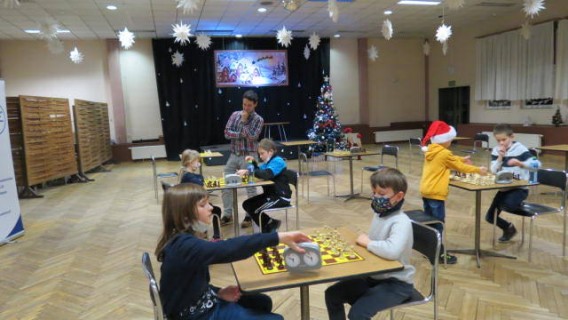 Dzieci graja w szachy sędzia kontroluje grę