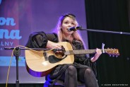 Gabriela Pec na scenie na siedząco z gitarą