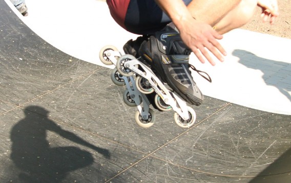Człowiek na rolkach wykonujący skok na torze w skateparku