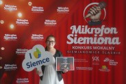 Anna Wolska na tle czerwonej ścianki reklamowej konkursu