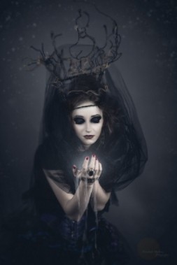 Postać kobiety ucharakteryzowana na czarownicę na mrocznym tle