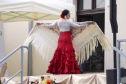 Tancerka flamenco Agnieszka Malicka w biało czerwonej sukni z falbanami podczas występu z chustą…