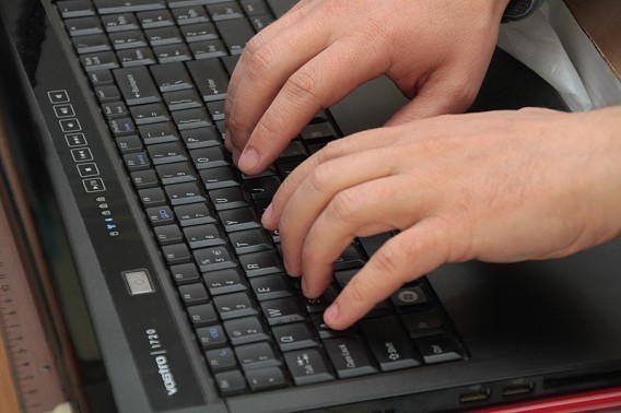Dłonie piszące na klawiaturze laptopa
