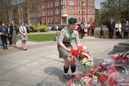 Harcerka składa kwiaty na Pomniku Czynu Powstańczego.