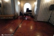 Mariusz Krajewski grający na fortepianie, widok ogólny sali w Willi Fitznera