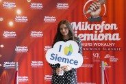 Justyna Bulenda na tle czerwonej ścianki reklamowej konkursu