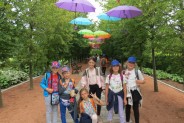 dzieci w ogrodach kapias w urokliwej alejce z parasolkami