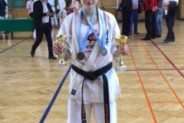 Daria Szefer z trofeami - pucharem i złotym medalem za rywalizację w kumite oraz srebrem za kata