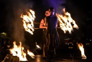 Występ teatru ognia Nam-Tara – dwie postacie żonglujące ogniem na czarnym tle