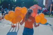 Industriada 2021 Park Tradycji dziewczyna stojąca tyłem z pękiem pomarańczowych balonów…