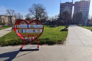 Czerwone serce – skarbonka w dzielnicy Michałkowice, w tle skwer i bloki